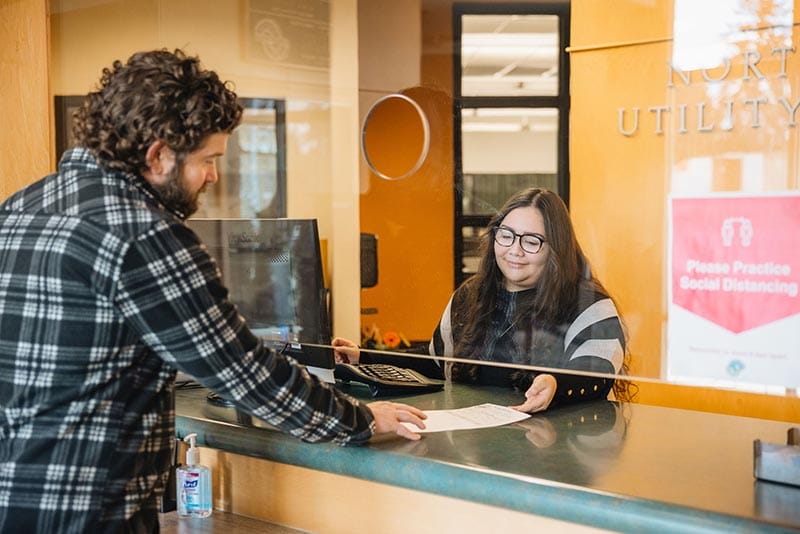 a woman handing a client some paperwork across a desk